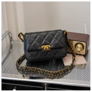 Close-up of quilted black leather texture and gold chain strap on vintage handbag