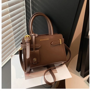 Détails du sac à main marron foncé avec boucles dorées et logo de marque en métal