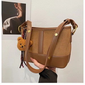Detail of leopard bucket bag showing brown leather texture and cute plush bear charm