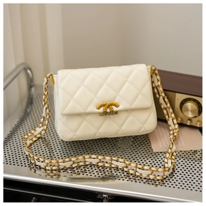 Detail of quilted beige leather bag featuring a gold chain strap and metallic clasp