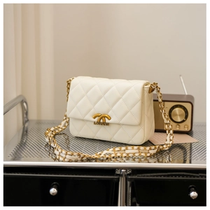 Detail of white quilted leather texture with gold metal buckle and leather chain strap