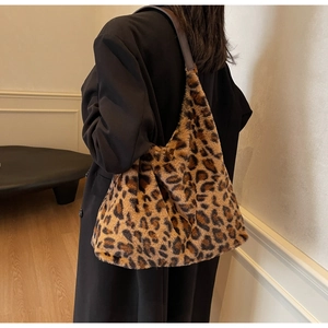 Dettaglio della borsa tote in peluche leopardata con tracolla marrone sulla spalla