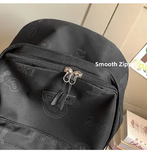 Detail of smooth double metal zippers and cute cartoon print on black backpack