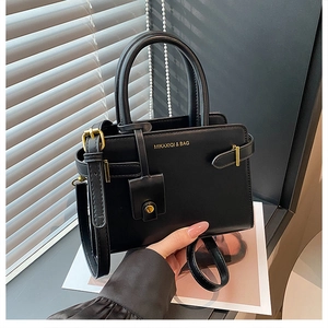 Détail du sac fourre-tout noir mat avec logo doré et petite pochette décorative