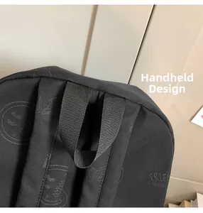Detail of the durable top handle and graffiti print on the black nylon backpack