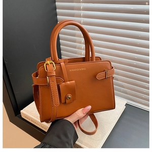 Détails du sac à main vintage en cuir marron avec logo doré et boucle décorative