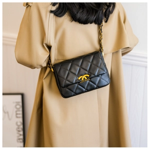 Detail of classic quilted shoulder bag with gold metal buckle and leather chain strap