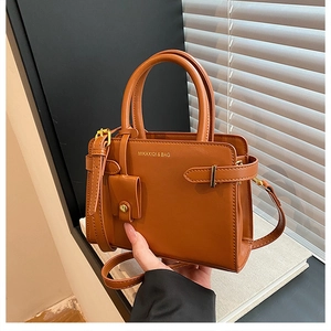 Détail du sac à main marron caramel avec logo de la marque et bandoulière réglable