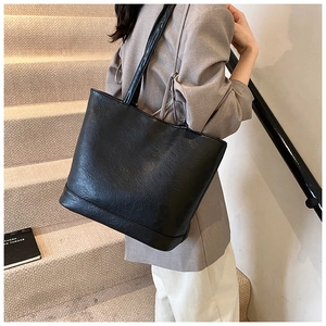 Seitenansicht einer großen schwarzen Damen-Tasche aus Kunstleder in Lifestyle-Umgebung