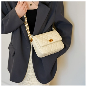 Quilted cream chain shoulder bag shown with metal chain strap and turn-lock closure