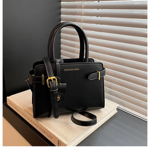 Vue détaillée du sac à main noir structuré avec boucles métalliques dorées élégantes