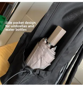 Detailed side pocket of black backpack holding a folded umbrella with drawstring closure