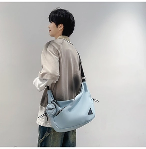 Close-up of light blue nylon dumpling bag with adjustable strap and coin purse