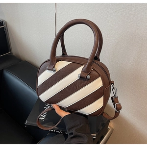 Dettaglio della borsa patchwork con trama litchi marrone e strisce color crema chic