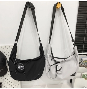 Detail of nylon dumpling bags in black and grey with wide straps and round coin purses