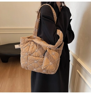 Detail of khaki quilted tote bag with floral embroidery and matching coin purse