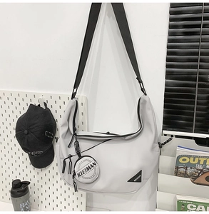 Detail of grey crescent bag with adjustable strap and small round coin purse