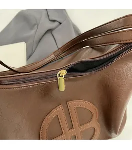 Detailed macro view of dark brown PU leather texture and smooth light gold zipper pull