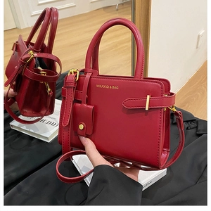 Détail du sac à main en cuir rouge avec ferrures dorées et sangle réglable