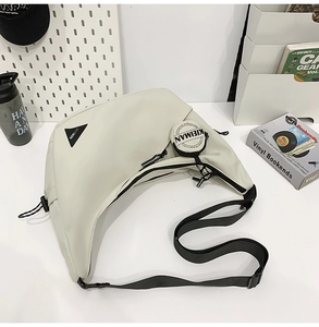 Detail view of cream-colored crescent bag with adjustable strap and mini round pouch