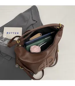 Top view of spacious brown tote bag interior with HB embossed logo and accessories