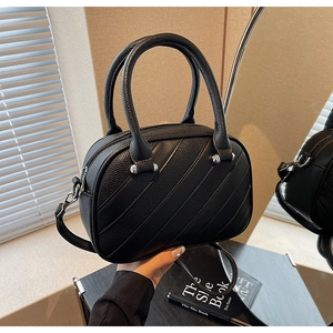 Dettaglio borsa nera in pelle PU con cuciture diagonali e finiture metalliche argentate
