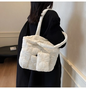 Detail of white quilted tote bag with floral embroidery and matching mini pouch