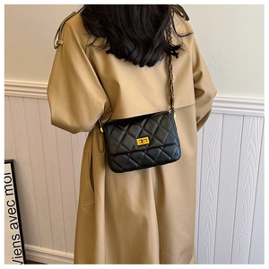 Chic black quilted shoulder bag with gold twist lock and chain strap on a model