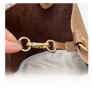 Close-up of premium golden metal swivel hook and brown lychee grain leather strap detail