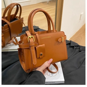 Détail d'un sac à bandoulière en cuir marron avec boucle en métal et sangle ajustable