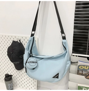 Detail of light blue crescent nylon bag with matching coin purse and KIEIMAN logo