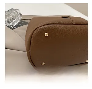 Detailed macro view of the brown leather bag base with four protective gold metal feet