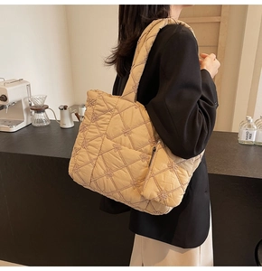 Detail of quilted tote bag with floral embroidery and matching small zipper pouch