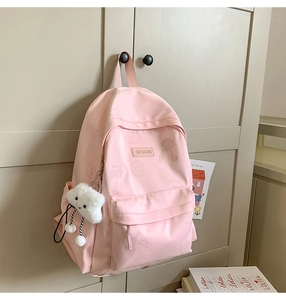 Detail of light pink backpack with cute letter prints and white cloud plush charm