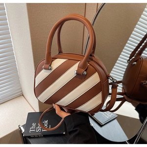 Dettaglio borsa bowling a righe in pelle con texture litchi e doppi manici corti