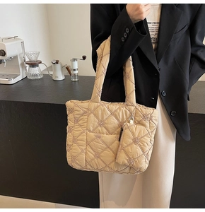 Detail of beige quilted tote bag with floral embroidery and matching mini zip pouch
