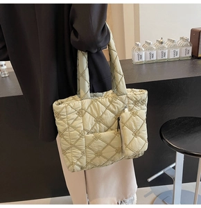 Detail of light green quilted tote bag with clover texture and matching coin purse