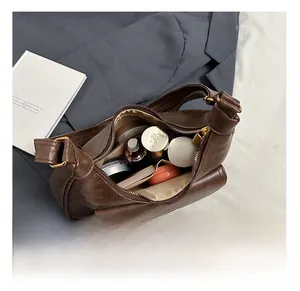 Vue détaillée de l'intérieur du sac à bandoulière marron avec rangement cosmétique