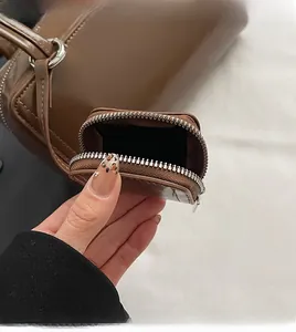 Detail view of a dark brown leather purse set with silver hardware and a small coin pouch
