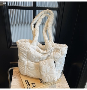 Detail of white quilted tote bag featuring floral embroidery and matching coin purse