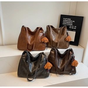 Detail of four colorful leather tote bags with cute teddy bear charms in a row