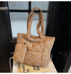 Detail of camel quilted tote bag with floral embroidery and detachable small pouch