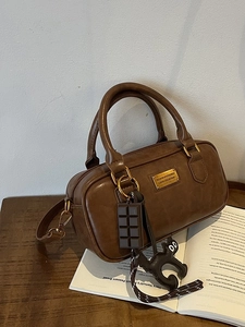 Retro brown cylinder pillow bag with gold hardware and creative cartoon pendants