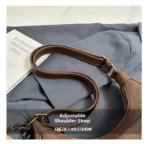 Détail de la bandoulière réglable et de la boucle en bronze vintage sur le sac en daim
