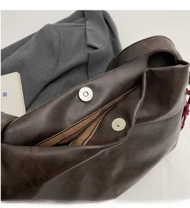 Detailed macro view of vintage brown tote bag with metallic magnetic buckle and striped lining