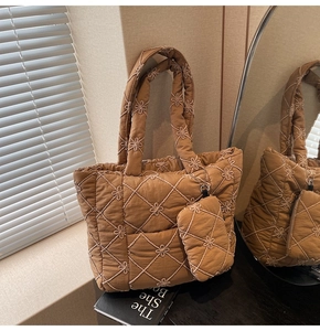 Close-up of brown quilted tote bag with star floral embroidery and a small matching pouch