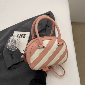 Dettaglio borsa a tracolla a righe rosa e beige con trama litchi e rivetti argentati