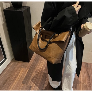 Détail du grand sac cabas en cuir souple marron avec poignées tressées et style épuré