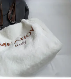 Close-up of plush white tote bag with MEAROY embroidery and soft faux fur texture