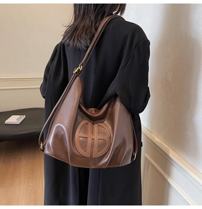 Detail of adjustable strap and golden hardware on a vintage brown leather tote bag
